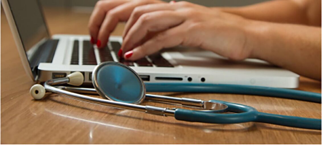 hands on laptop with stethoscope